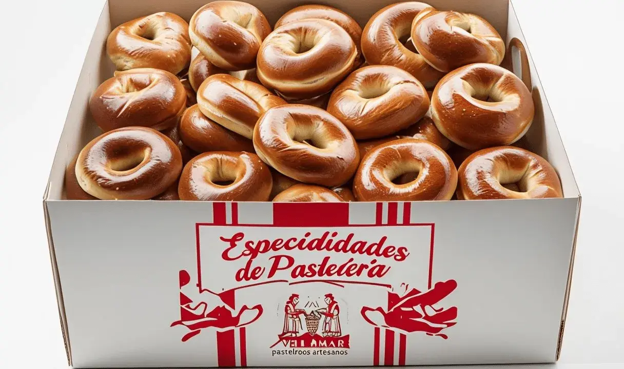 Caja llena de rosquillas de palo doradas y brillantes, listas para ser disfrutadas.