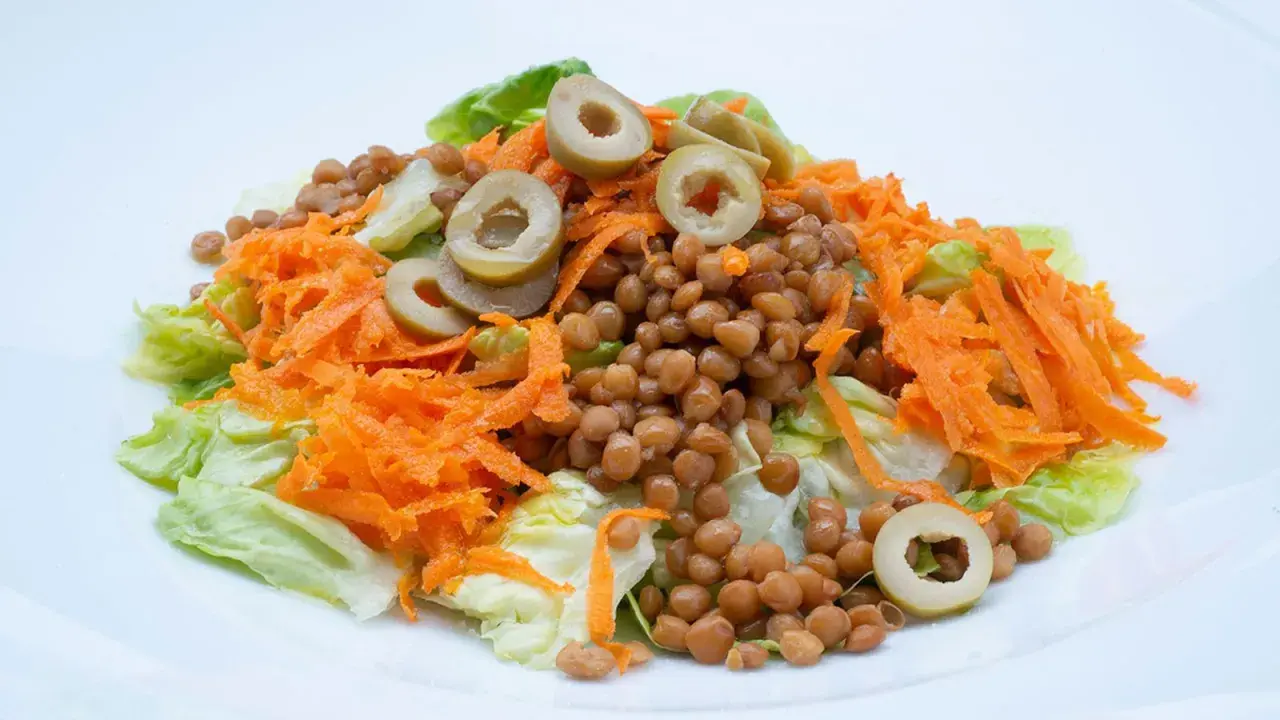 Ensalada de lentejas con zanahoria rallada y aceitunas, un plato fresco y saludable, estilo Arguiñano.