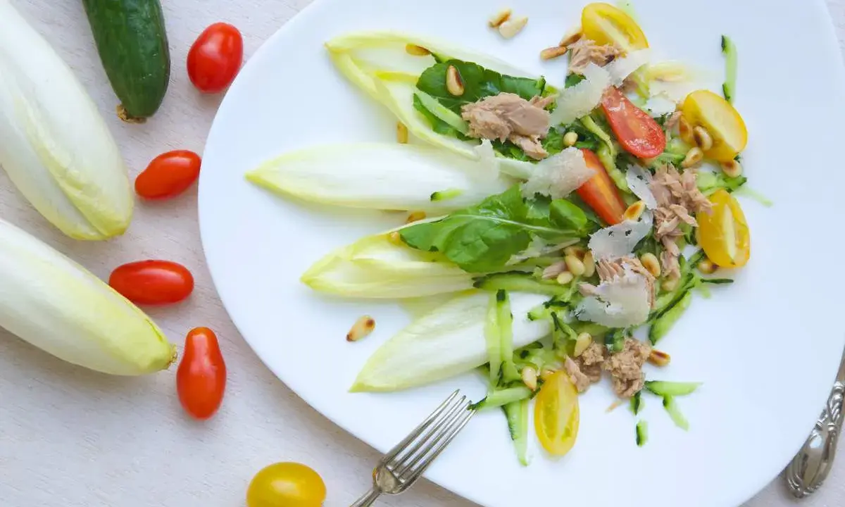 Deliciosa ensalada de endivias con atún, tomate, pepino y piñones. Un plato fresco y ligero.
