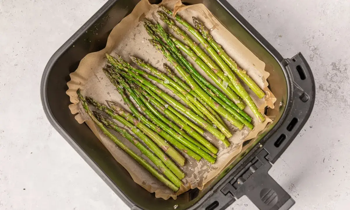 Espárragos frescos listos para cocinar en la airfryer, con un toque de sal y aceite.