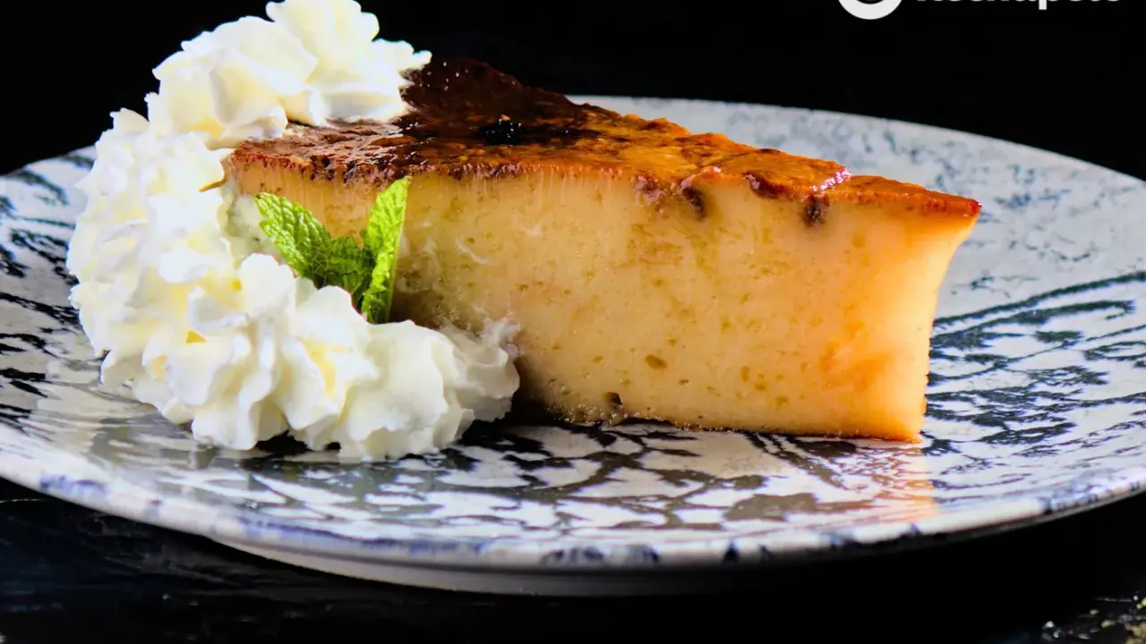 Rebanada de pan de calatrava con nata montada y menta, servida en un plato decorado.