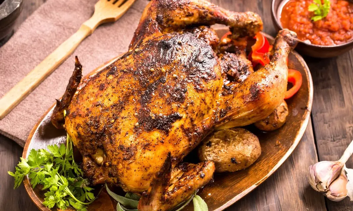 Un delicioso pollo al horno crujiente y jugoso, servido con patatas asadas, pimientos rojos y salsa. ¡Perfecto para una comida familiar!