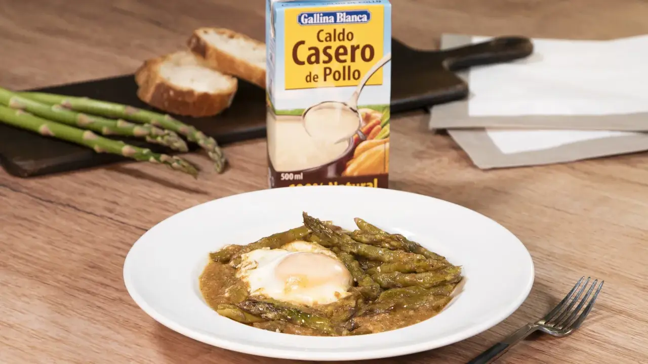 Espárragos esparragados con huevo frito, pan y caldo de pollo Gallina Blanca.
