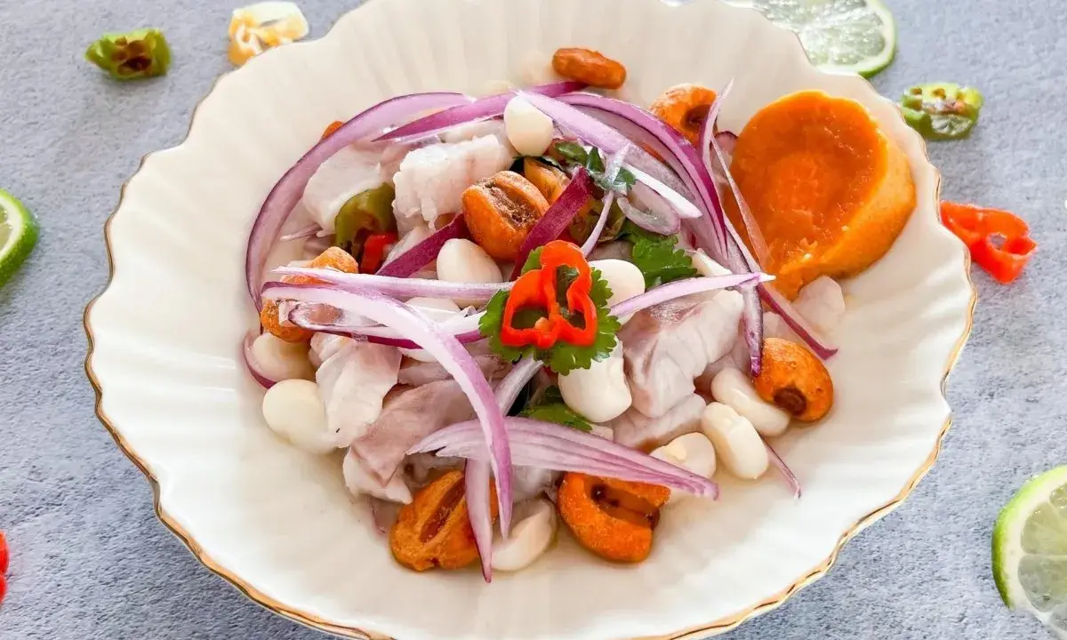 Delicioso ceviche de lubina con camote, choclo, cebolla roja y ají. Frescura y sabor en cada bocado.