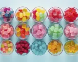 Cuencos llenos de gominolas caseras de colores vibrantes: azules, rosas, rojas, verdes, amarillas y naranjas.