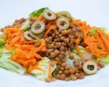 Ensalada de lentejas con zanahoria rallada y aceitunas, un plato fresco y saludable, estilo Arguiñano.