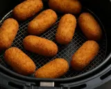 Croquetas doradas y crujientes listas en la freidora de aire.