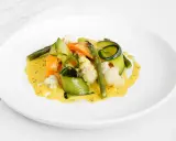 Deliciosas verduras al vapor, como zanahoria, calabacín en espiral, espárragos y coliflor, bañadas en una cremosa salsa amarilla.
