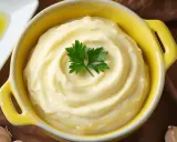 Alioli casero en un cuenco amarillo, decorado con perejil. ¿Cuánto dura el alioli casero en la nevera?