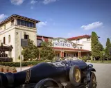Un coche clásico negro frente a las Cavas Freixenet en Penedès.