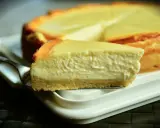 Una rebanada cremosa de tarta de queso Philadelphia, con su base dorada y relleno suave, lista para ser disfrutada.