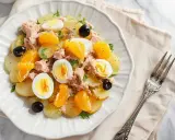 Ensalada malagueña con patatas, atún, huevos duros, aceitunas negras y gajos de mandarina.