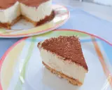 Delicioso cheesecake con cacao espolvoreado, listo para disfrutar. Una receta perfecta para cualquier ocasión.