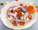 Delicioso ceviche de lubina con camote, choclo, cebolla roja y ají. Frescura y sabor en cada bocado.