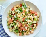 Ensalada garbanzos fresca con tomate, pepino, aceitunas y perejil. Un plato ligero y nutritivo.