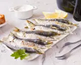 Sardinas en freidora de aire, doradas y crujientes, listas para disfrutar con limón y pan.