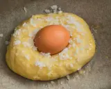 Masa para receta mona de pascua esponjosa, con un huevo crudo incrustado y espolvoreada con azúcar.