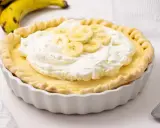 Deliciosa tarta de plátano con crema batida y rodajas de plátano fresco.