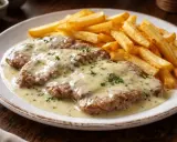 Escalopines de ternera con salsa cremosa y patatas fritas doradas, un plato clásico y delicioso.