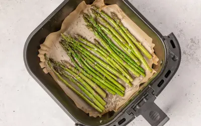 Espárragos frescos listos para cocinar en la airfryer, con un toque de sal y aceite.