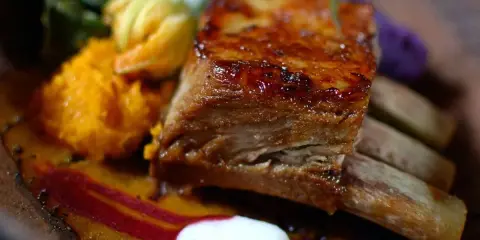 Costillas en freidora de aire, jugosas y doradas, acompañadas de puré de calabaza, vegetales verdes y un toque de remolacha.