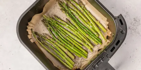 Espárragos frescos listos para cocinar en la airfryer, con un toque de sal y aceite.