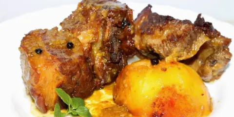 Tierna falda de ternera al horno, jugosa y dorada, servida con patatas asadas y un toque de hierbas.