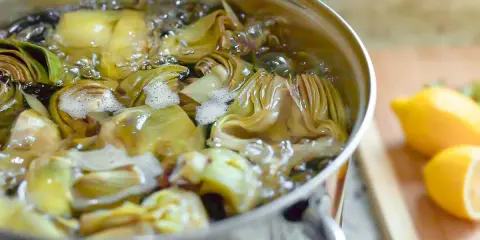 Alcachofas cortadas hirviendo en una olla. Aprende como cocer alcachofas para un plato delicioso.