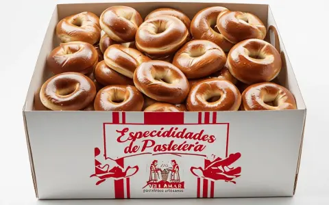 Caja llena de rosquillas de palo doradas y brillantes, listas para ser disfrutadas.