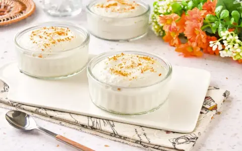 Delicioso mousse de yogur en vasitos de cristal, espolvoreado con canela. Un postre ligero y refrescante.