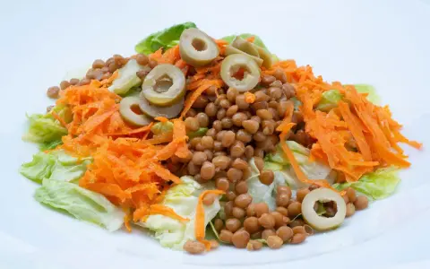 Ensalada de lentejas con zanahoria rallada y aceitunas, un plato fresco y saludable, estilo Arguiñano.