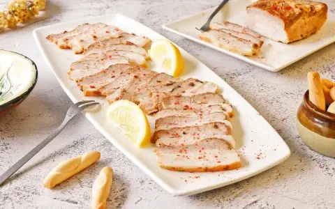 Chicharrón de Cádiz en lonchas, servido con limón y picos. Un plato que evoca el sabor de Andalucía.
