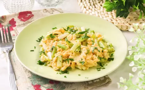 Revuelto de ajetes con perejil fresco, servido en un plato verde claro.