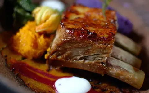 Costillas en freidora de aire, jugosas y doradas, acompañadas de puré de calabaza, vegetales verdes y un toque de remolacha.