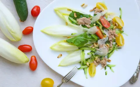 Deliciosa ensalada de endivias con atún, tomate, pepino y piñones. Un plato fresco y ligero.