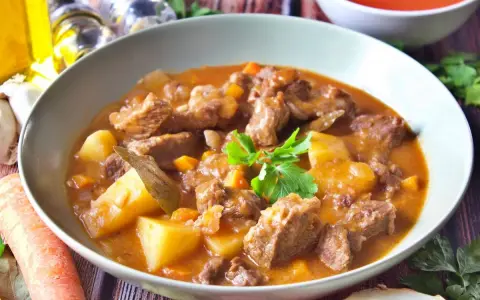Un reconfortante plato de patatas guisadas con trozos de carne tierna, zanahorias y patatas en una rica salsa.