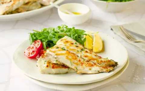 Deliciosa corvina a la plancha, servida con rúcula fresca, tomates cherry y gajos de limón. Un plato ligero y sabroso.
