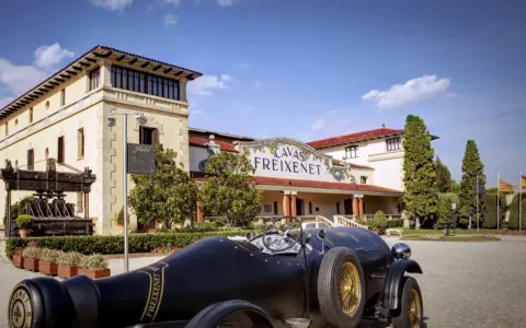 Un coche clásico negro frente a las Cavas Freixenet en Penedès.