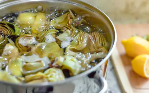 Alcachofas cortadas hirviendo en una olla. Aprende como cocer alcachofas para un plato delicioso.