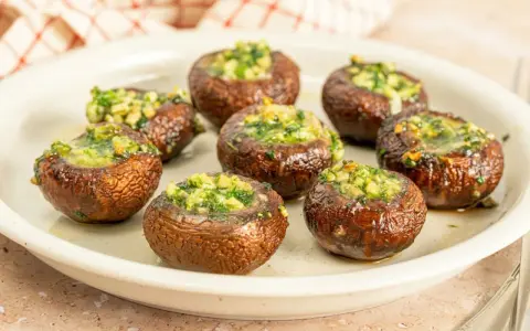 Champiñones rellenos, dorados y jugosos, recién salidos de la freidora de aire. Perfectos para un aperitivo rápido y delicioso.
