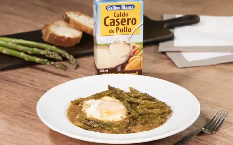 Espárragos esparragados con huevo frito, pan y caldo de pollo Gallina Blanca.