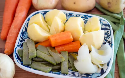 Plato de hervido valenciano con patatas, zanahorias, judías verdes y cebolla.
