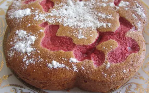 Bizcocho de fresa con azúcar glas espolvoreado, con un diseño interior de color rosa vibrante.