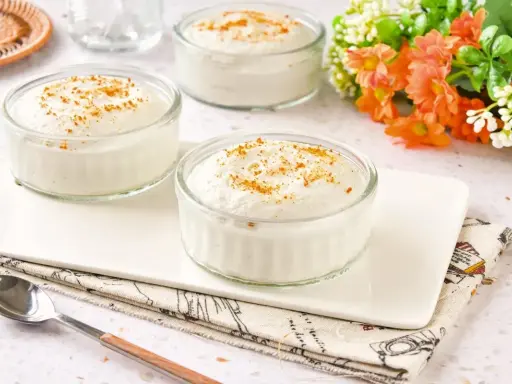 Delicioso mousse de yogur en vasitos de cristal, espolvoreado con canela. Un postre ligero y refrescante.