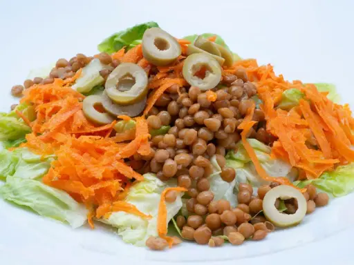 Ensalada de lentejas con zanahoria rallada y aceitunas, un plato fresco y saludable, estilo Arguiñano.