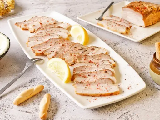 Chicharrón de Cádiz en lonchas, servido con limón y picos. Un plato que evoca el sabor de Andalucía.