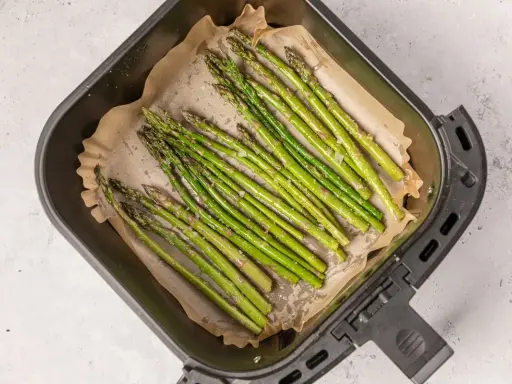 Espárragos frescos listos para cocinar en la airfryer, con un toque de sal y aceite.