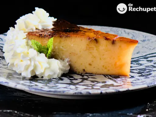 Rebanada de pan de calatrava con nata montada y menta, servida en un plato decorado.