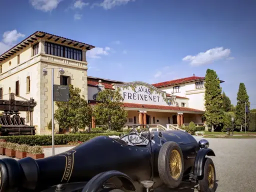 Un coche clásico negro frente a las Cavas Freixenet en Penedès.