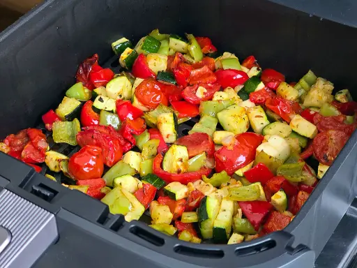 Verduras asadas en airfryer: pimientos rojos y verdes, calabacín y tomates cherry, listos para disfrutar.